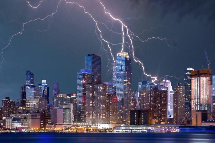 a city skyline with lighting strikes overhead