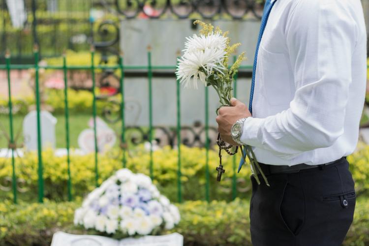 funeral mourner laying flowers on a casket