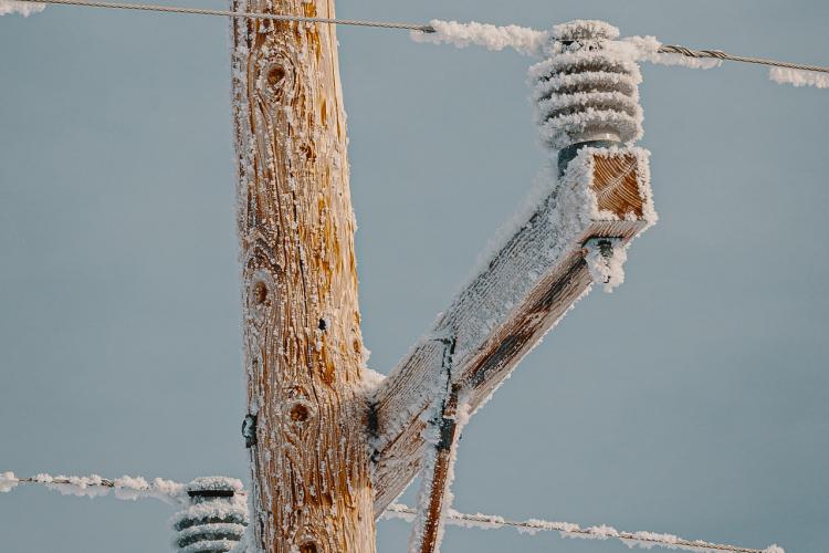 Electric post and wires covered with snow