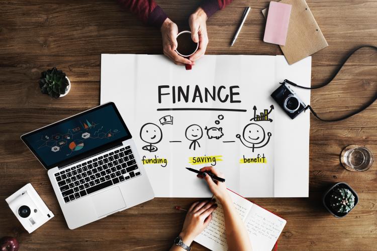 a table with a laptop and a piece of paper that says "finance" on it