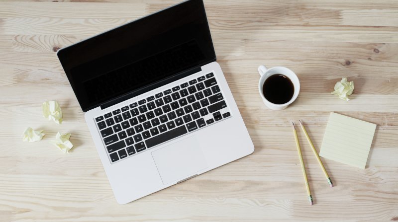 laptop with coffee and pencils on a tabletop